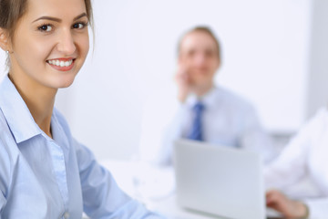 Obraz premium Beautiful business woman on the background of business people during meeting