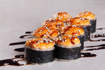 Roll cap salmon and perch, sesame, unagi on a white background isolated close-up menu for sushi oriental