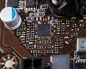 Macro closeup of a computer PCB Motherboard using brown and blac