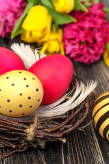 Easter egg nest with flowers on rustic wooden background