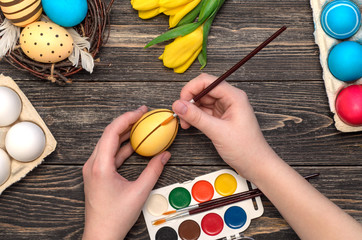 Girl's hand painting Easter eggs