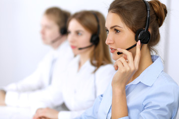 Call center. Focus on beautiful woman in headset