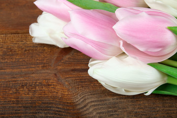 Fototapeta na wymiar beautiful and fragrant blooming pink and white tulips on a brown wooden background