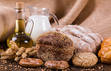 Assortment of baked bread on wooden table background