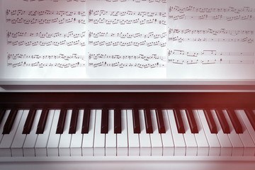 Piano keyboard and musical notes close up