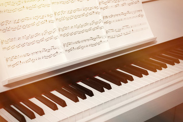 Fototapeta na wymiar Piano keyboard and musical notes close up