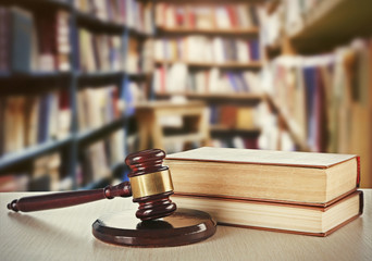 Wooden judges gavel and law books on table in library