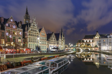 Obraz premium Picturesque medieval building and St Michael's Bridge on the quay Graslei in Leie river at Ghent town at night, Belgium