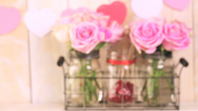 Pink roses in jars and gifts on rustic wood shelf for Valentines DAy