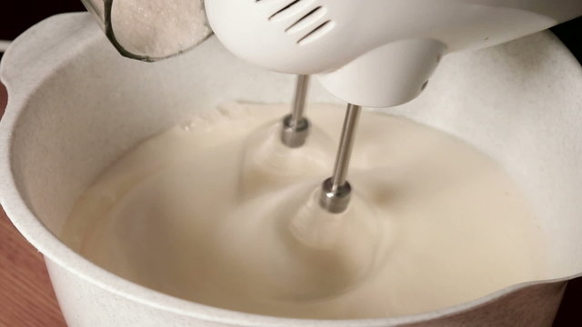 mixer knoks egg whites and pour sugar Close up