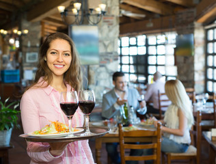 Waiter with restaurant guests at table