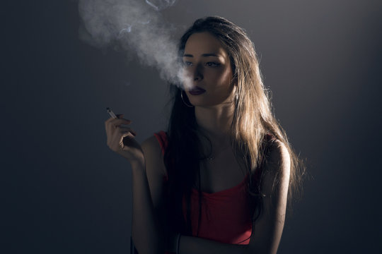 Beautiful young woman with a cigarrette.