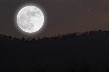 Fototapeta na wymiar Full moon with stars over mountain on darkness sky.