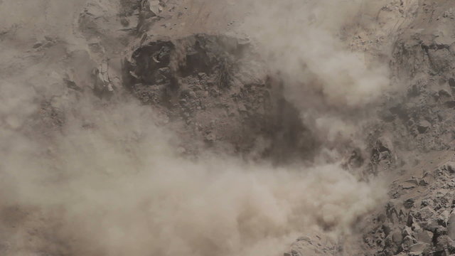 A powerful earthquake-triggered landslide on a rocky slope sends a massive cloud of dust and debris into the air in Tungurahua province, Ecuador, captured from a high angle.