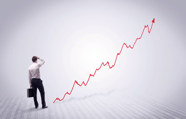 Standing businessman with red graph arrow