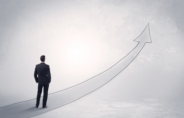 Obraz premium Business man standing on drawn arrow