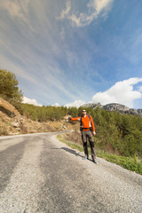 A man with a backpack on the road traveling.