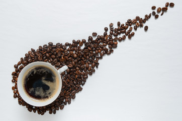 Comet shape made of coffee grains on white table