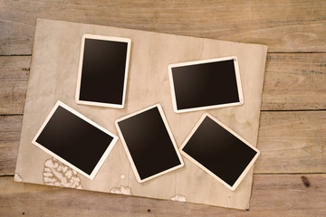 Fototapeta premium Empty instans album on wood table. paper photo of camera - vintage and retro style