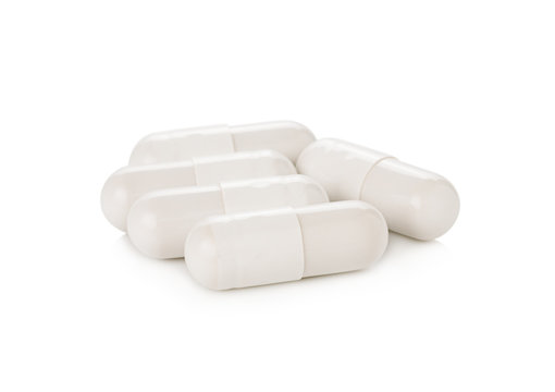 white pill capsules on white background
