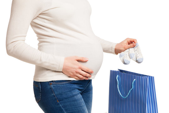  happy pregnent woman holding clothes of child