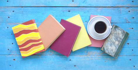 multicolored books and a cup of coffee, flat lay