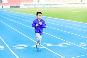 Fototapeta premium Boy runnin on blue track