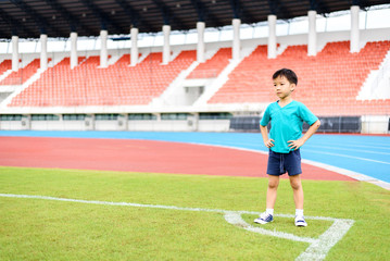 Fototapeta premium Boy stand on the football field.