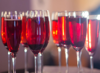 Beautiful row line of different colored alcohol cocktails with mint on a christmas party, martini, vodka,and others on decorated catering bouquet table on open air event, picture with beautiful bokeh