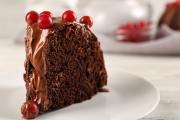 Piece of chocolate cake with snowball tree berries on a table