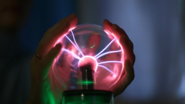 People touching hands of a lightning magic ball
