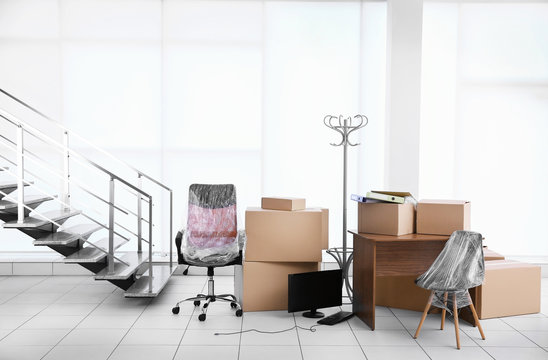 Moving cardboard boxes and personal belongings near stairs in office