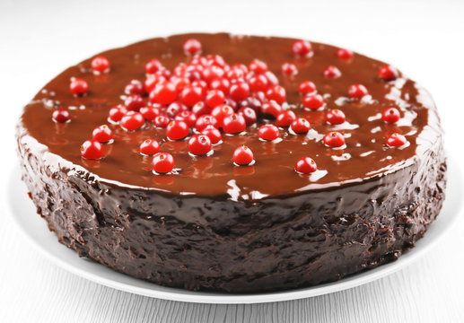 Chocolate cake with cranberries on plate, closeup