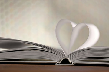 Heart from book pages on blurred background