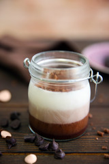 Delicious vanilla-chocolate mousse on wooden background, close up