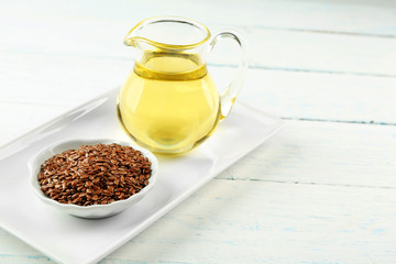 Flax seeds and oil on wooden table