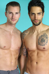 two sexy men posing over a blue background