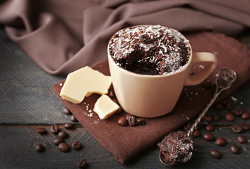 Chocolate fondant cake in cup on wooden table closeup