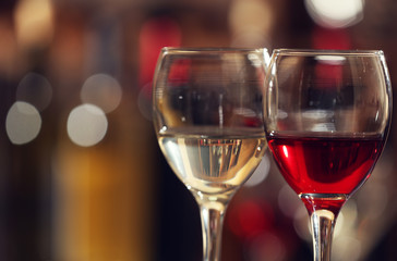 Glasses of red and white wine against blurred background