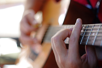 musician playing on an old acoustic guitar