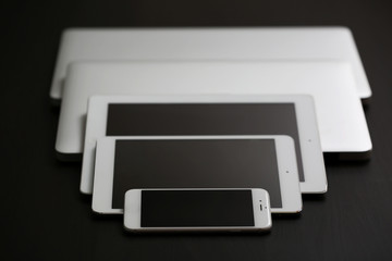 A set of electronic devices on a dark desk