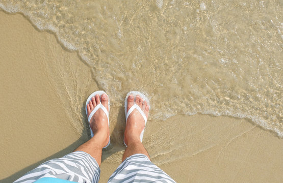 White flipflop sandals on sea beach