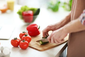 Man chopping vegetables in kitchen