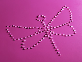 Dragonfly made of water drops on purple background