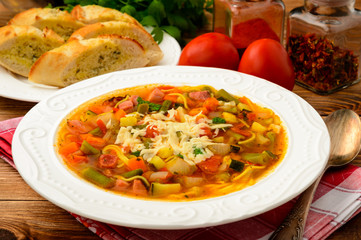 Minestrone- italian soup with vegetables on brown wooden table.