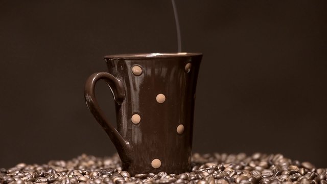 Cup and roasted coffee slow rotation