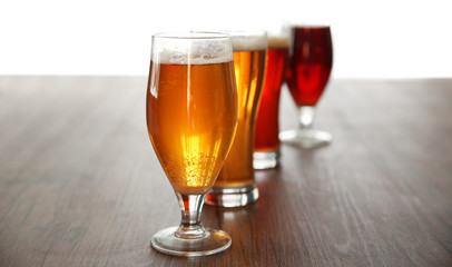 Glasses with different sorts of craft beer on wooden table