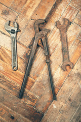 Set of old wrenches on wooden floor