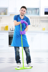 Man with mop in the kitchen