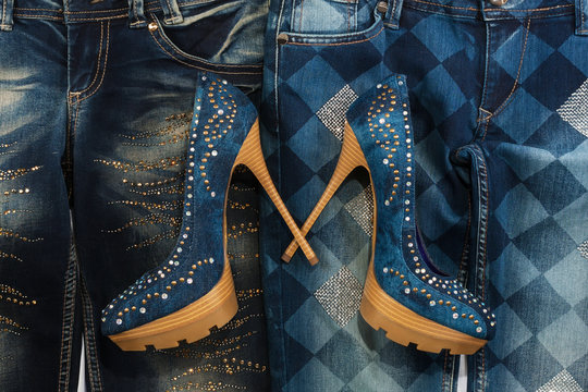 Glamorous women's fashion, jeans, shoes in rhinestones, lying on jeans